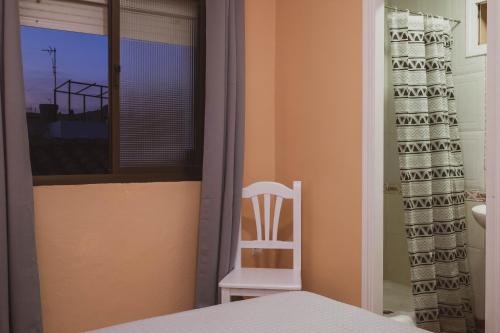 a bedroom with a chair and a window at Sanvi Xerez Centro in Jerez de la Frontera