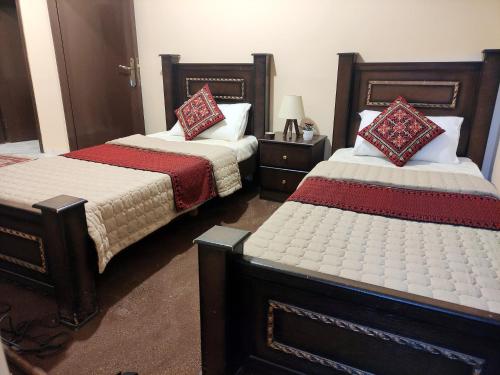 two beds in a hotel room with sidx sidx sidx sidx at Majido Hotel in Wadi Musa
