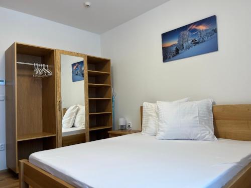 um quarto com uma cama grande e algumas prateleiras em Apartmány Nýdečanka em Nýdek