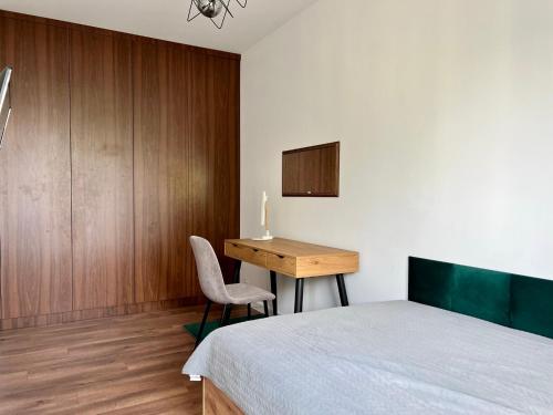 a bedroom with a bed and a desk and a table at PRIMO Premium Apartments Łódź Fabryczna in Łódź