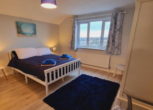 ein Schlafzimmer mit einem Bett und einem großen Fenster in der Unterkunft Captivating & Cosy 4-Bedroom House in Magherafelt in Magherafelt