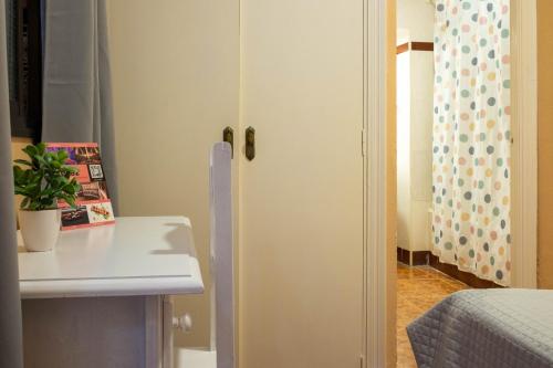 a kitchen with a white cabinet next to a bed at Sanvi Xerez Centro in Jerez de la Frontera