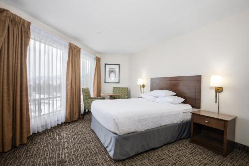 a hotel room with a bed and a large window at Ramada by Wyndham Kamloops in Kamloops