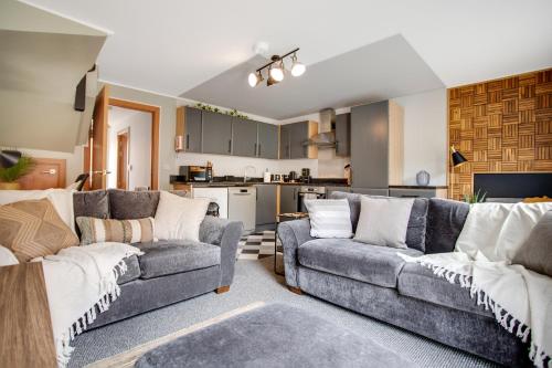 Una sala de estar con dos sofás y una cocina. en New! Peaceful 4 Bed home - Quiet and Cosy, en Kent