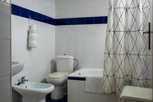 a white bathroom with a toilet and a sink at Sanvi Xerez Centro in Jerez de la Frontera