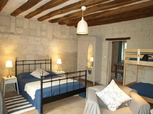 a bedroom with two beds and a living room at Les gîtes de la Madeleine in La Chapelle-sur-Loire