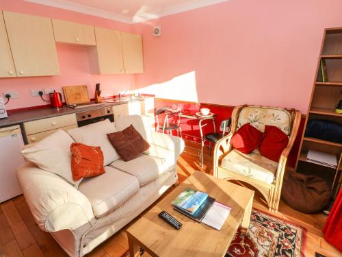 a living room with a white couch and a table at Cwtch Cowin in Banc-y-felin