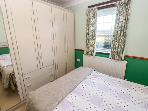 um quarto com uma cama e uma janela em Cwtch Cowin em Banc-y-felin