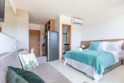 a bedroom with a bed and a refrigerator at Mana Beach #B217 - Quadrúplo por Carpediem in Porto De Galinhas