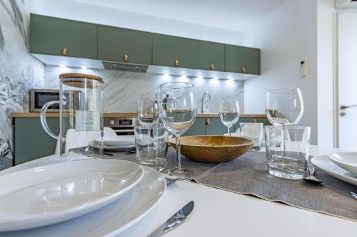 a table with wine glasses and plates on it at Le Green Duplex - Clim - Parking - Netflix - Nestor & Margot in Auterive