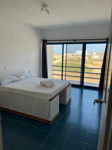a bedroom with a bed and a large window at Beach Rotxa in Vila do Maio