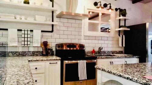 a kitchen with white cabinets and a black stove at Casa Los Madriz Suite #2 in San Isidro