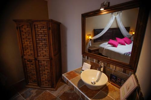 a bathroom with a sink and a large mirror at La Escondida Hotel Boutique in Zacatlán