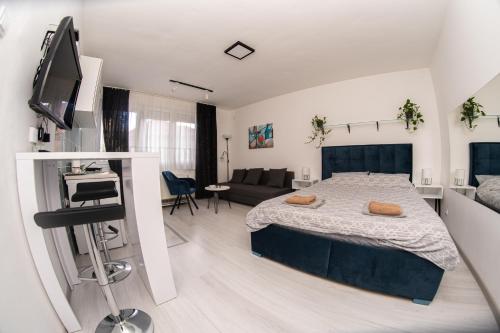 a bedroom with a bed and a living room at Stan na dan CENTRAL Uzice in Užice