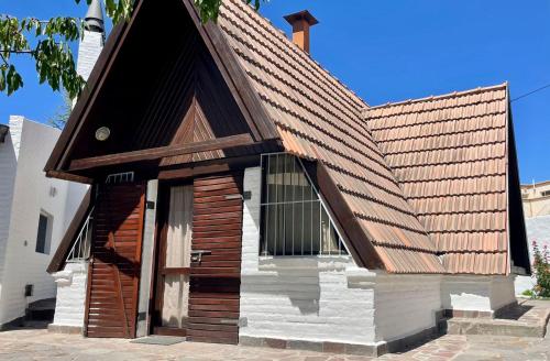 un edificio con techo de madera y puerta en La Cabaña de Puerto Madryn en Puerto Madryn