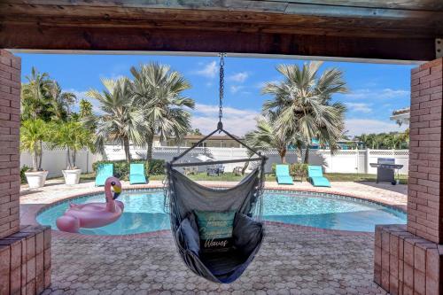 a hammock hanging in front of a swimming pool at Tropical Escape - Heated Pool - Game Room in Hollywood