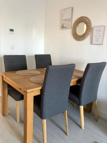 a wooden table with four chairs and a mirror at Fin Albir Playa in Albir