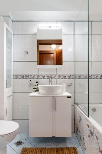 a bathroom with a sink and a toilet and a tub at Volos luxury maisonette-Pelion view in Volos