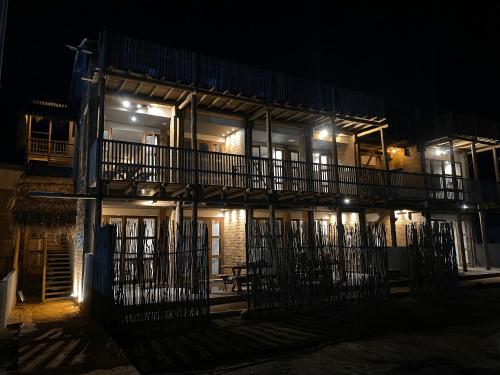 um edifício iluminado com uma varanda à noite em Kaha Mar - Patacho em Porto de Pedras