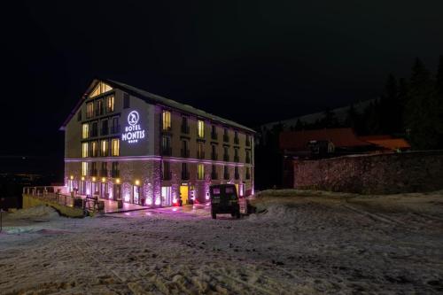 un edificio con un cartel en su costado por la noche en Montis Hotel & Spa en Muntele Mic