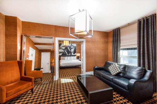 a living room with a couch and a bedroom at Ameritania at Times Square in New York