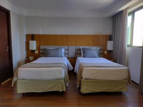 una habitación de hotel con 2 camas en una habitación en Ótima Localização, reformado e com piscina!, en Río de Janeiro
