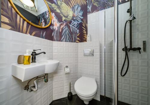 ein Bad mit einem WC, einem Waschbecken und einer Dusche in der Unterkunft Apartament Żurawia street in Warschau