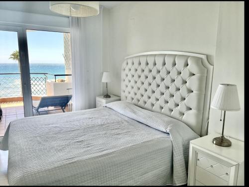 Sitio de CalahondaにあるMI CAPRICHO A12 BEACHFRONT - Apartment with sea view- Costa del Solの白いベッドルーム(大型ベッド1台、バルコニー付)