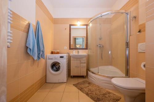 a bathroom with a shower sink and a washing machine at Apartament na prywatnym Osiedlu! in Grzybowo