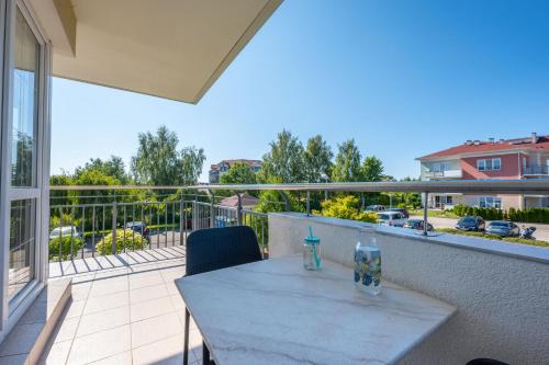a table and chairs on a balcony with a view at Apartament na prywatnym Osiedlu! in Grzybowo
