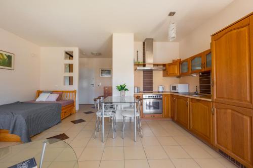 a kitchen and living room with a bed and a table at Apartament na prywatnym Osiedlu! in Grzybowo