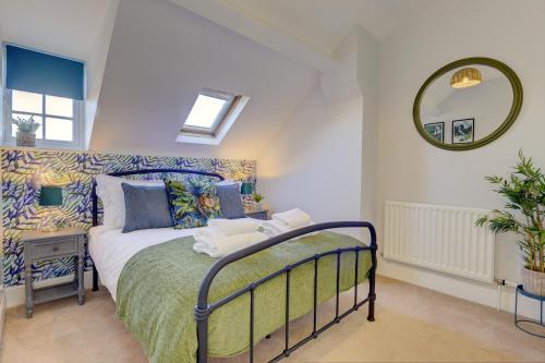 een slaapkamer met een bed en een spiegel bij Regency Nest by Spa Town Property - Stylish 3 Bedroom Apartment on 2 Floors, Central Leamington Spa in Leamington Spa