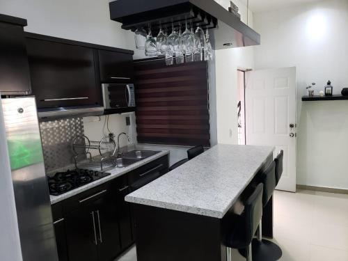 a kitchen with black cabinets and a counter top at Departamentos L in Cuauhtémoc