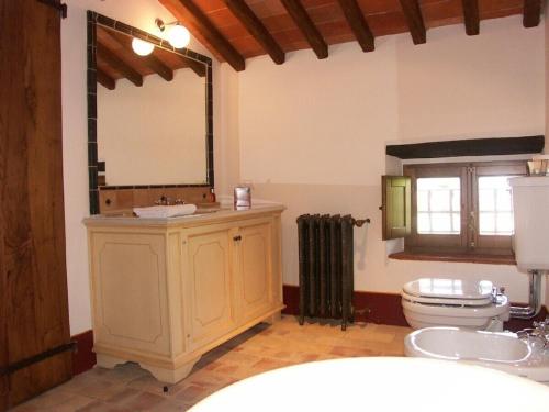a bathroom with a sink and a toilet and a mirror at Palazzo Prugnoli, Monte Santa Maria Tiberina, 8 Bedroom villa with private pool & superb views in Perugia