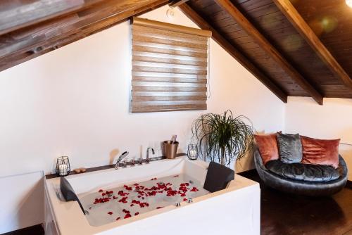 a bathroom with a large bath tub with red flowers at Volos luxury maisonette-Pelion view in Volos