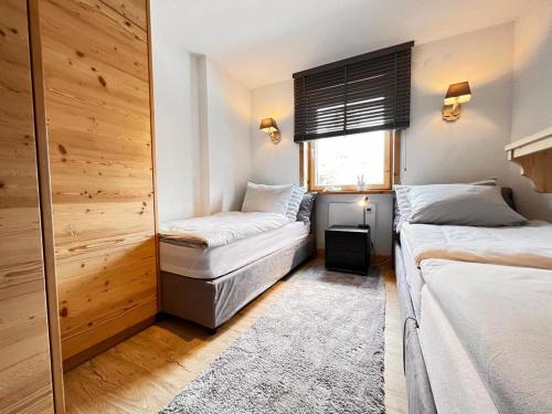 a bedroom with two beds and a window at Haus Diel - Premium Apartments mit Küche in Pettneu am Arlberg