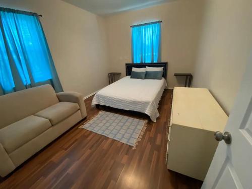 a bedroom with a bed and a couch and blue curtains at The Lofts at Myrtle in El Paso