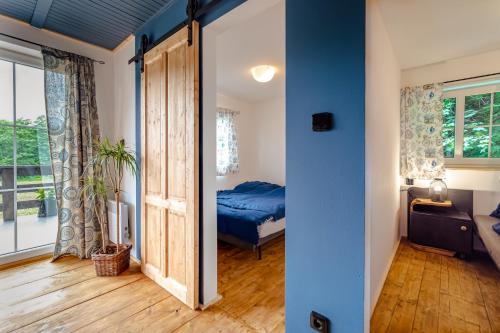 a bedroom with a bed and a sliding door at Chata U Tří lišek - na samotě u lesa 