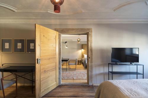 a room with a bed and a door with a television at Hotel Sonne in Zittau