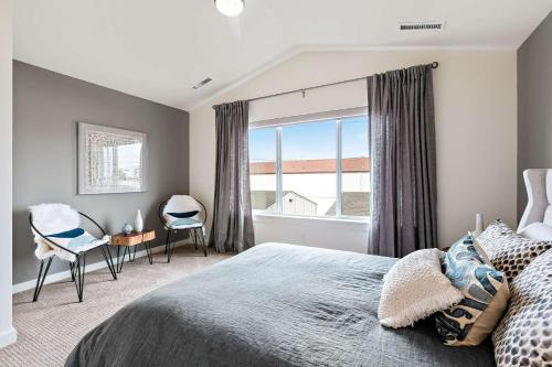 um quarto com uma cama, uma janela e cadeiras em Brit and Belle Townhouse em Boise