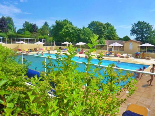una gran piscina con gente sentada a su alrededor en Vakantie Woning Le Chat Maison 175 en Écuras