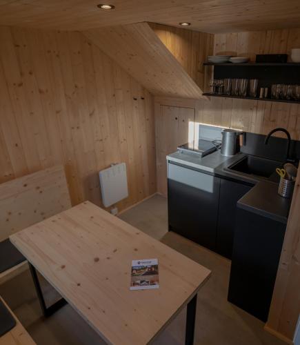 a kitchen with wooden walls and a wooden table at PRIMÁTOR CAMPING RESORT LITOMYŠL in Litomyšl