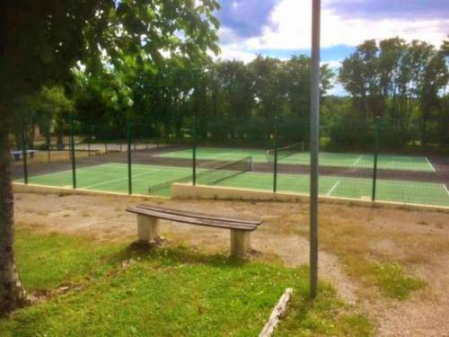 a bench on a tennis court with two tennis courts at Vakantie Woning Le Chat Maison 175 in Écuras