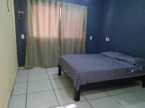 a bedroom with a bed and a blue wall at Hermosa casa En el centro isla Aguada in Ciudad del Carmen
