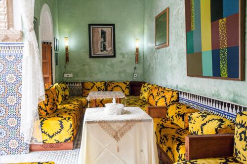 a living room with yellow couches and a table at Dar Shaeir in Rabat