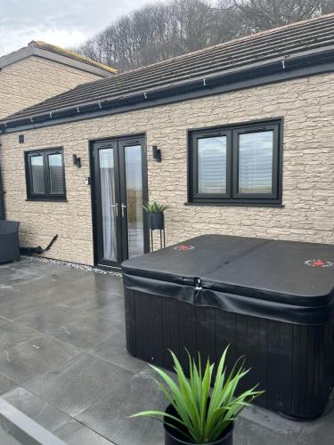 a house with a hot tub in front of it at Terfyn Hall holiday Apartment 2 in Prestatyn