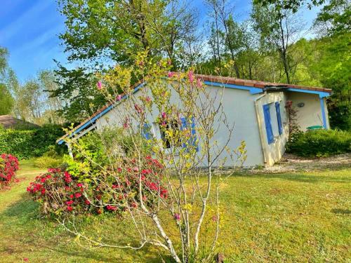 a small house with flowers in front of it at Vakantie Woning Le Chat Maison 175 in Écuras