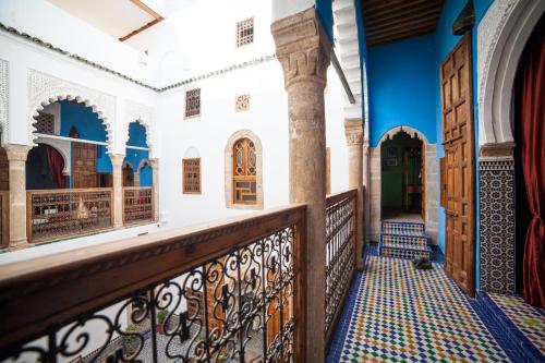 a balcony with blue and white walls and wooden doors at Dar Shaeir in Rabat