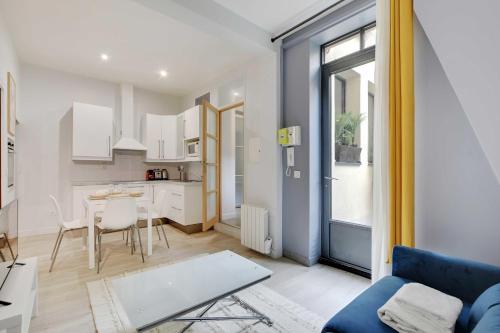 un salon avec un canapé bleu et une table dans l'établissement Charming apartment - 1BR-4P - Montparnasse, à Paris