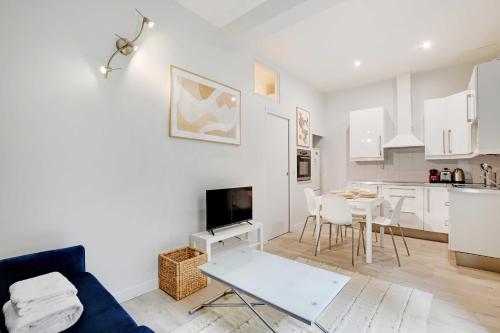 un salon avec un canapé et une table et une cuisine dans l'établissement Charming apartment - 1BR-4P - Montparnasse, à Paris